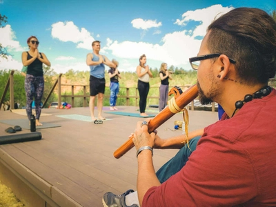 Man playing the flute for a yoga class.